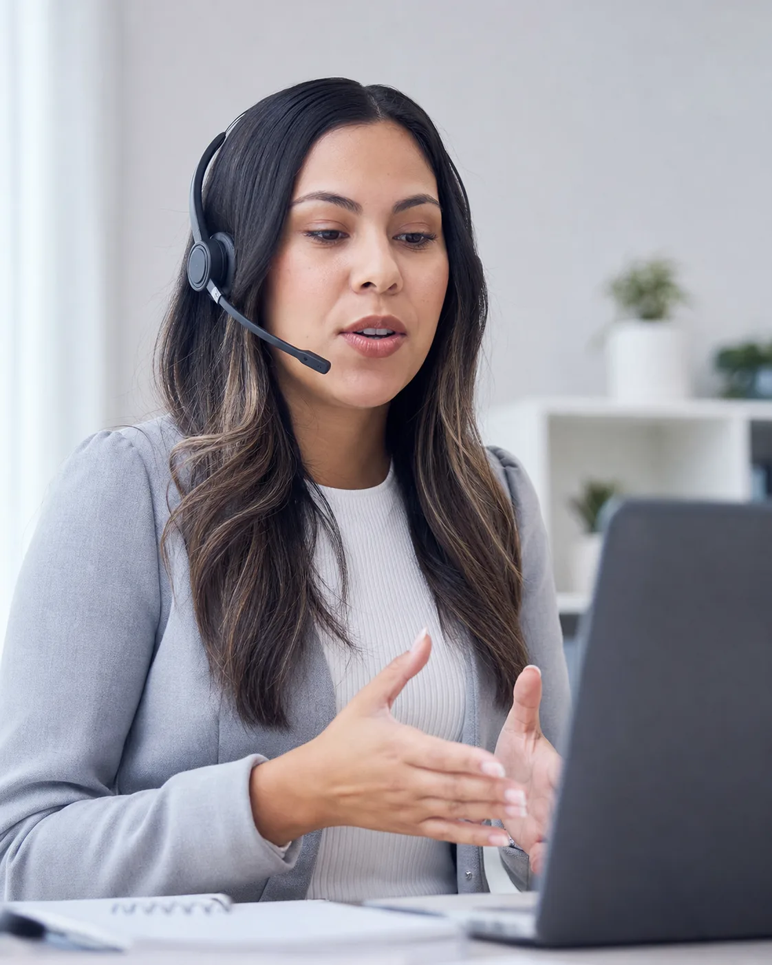 A support representative speaking while using a laptop